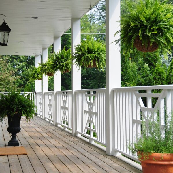 An elegant custom porch with stylish furniture, overhead lighting, and a seamless transition to the home’s interior.