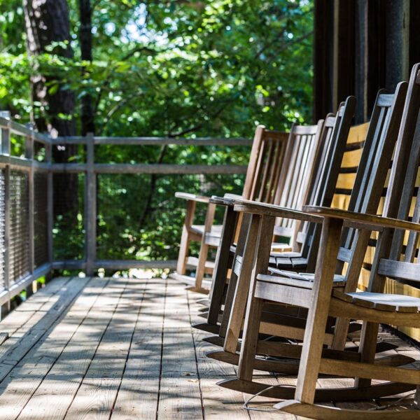 A charming custom porch adorned with hanging plants and cozy seating, creating a welcoming outdoor atmosphere.